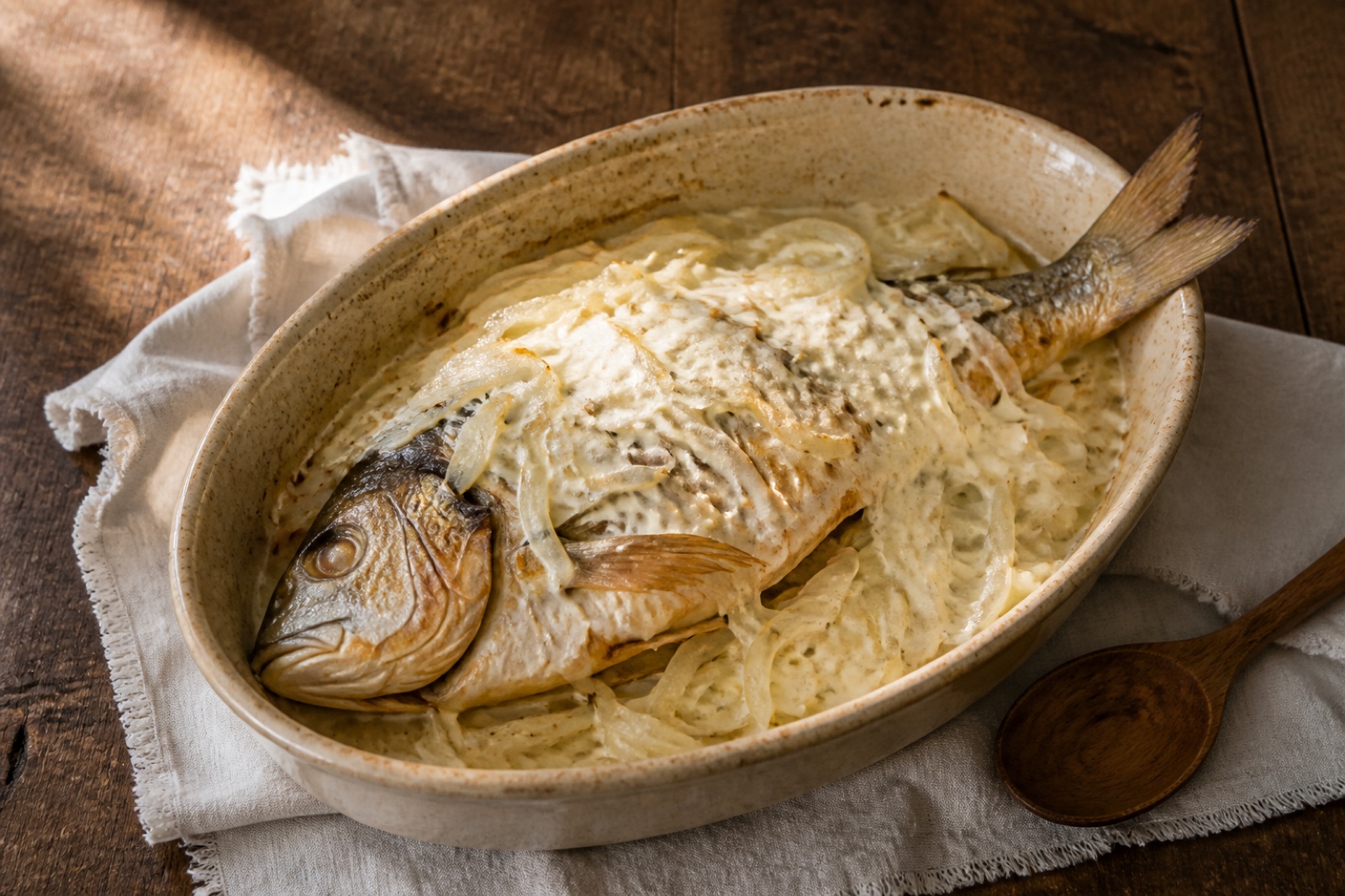 Целая рыба, запечённая с репчатым луком и сметаной